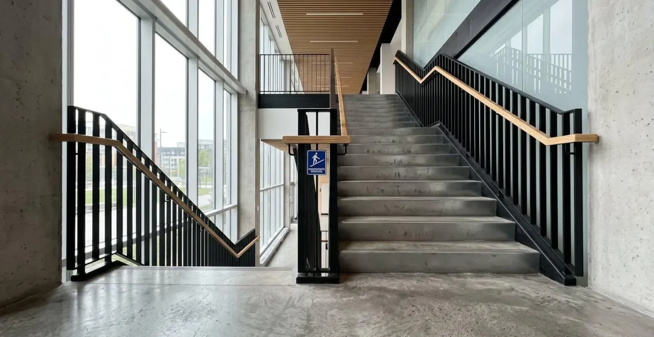 Escalier intérieur d'un lieu événementiel québécois avec rampe moderne, éclairage naturel et surfaces nettes